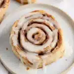 Warm tortilla cinnamon rolls topped with sweet glaze on a serving plate